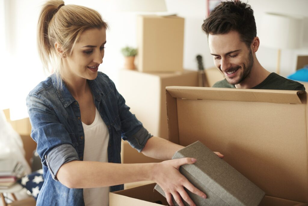 Couple organizing stuff from cardboard boxes