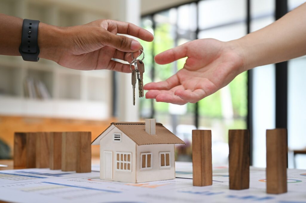 Cropped imaged of male real estate agent giving keys of new house to customer.