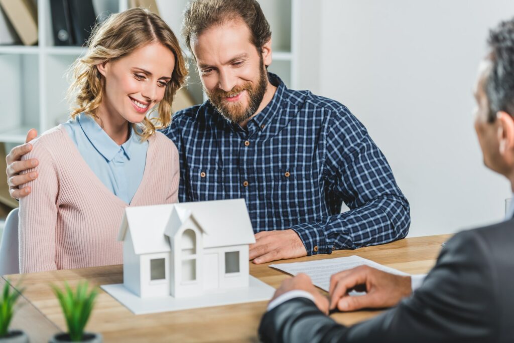portrait of couple having meeting with realtor in real estate agency office