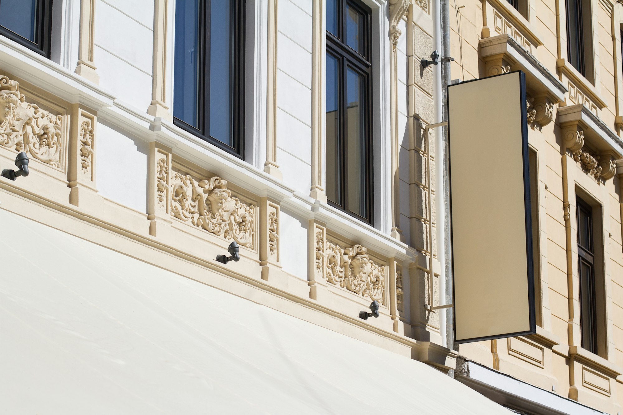 Vertical empty signboard on a building with classical architectu